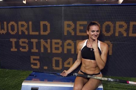 Isinbajevová před tabulí, která ukazuje světový rekord.