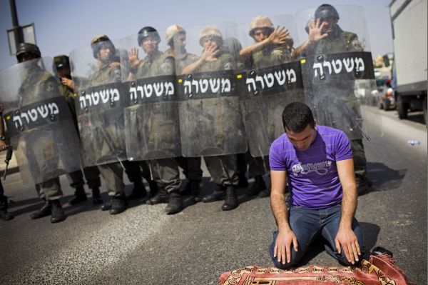 Palestinec, který se nedostal k mešitě al-Aksá, se modlí na ulici.