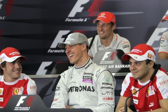 Michael Schumacher (uprostřed), nad ním smějící se Jenson Button. 