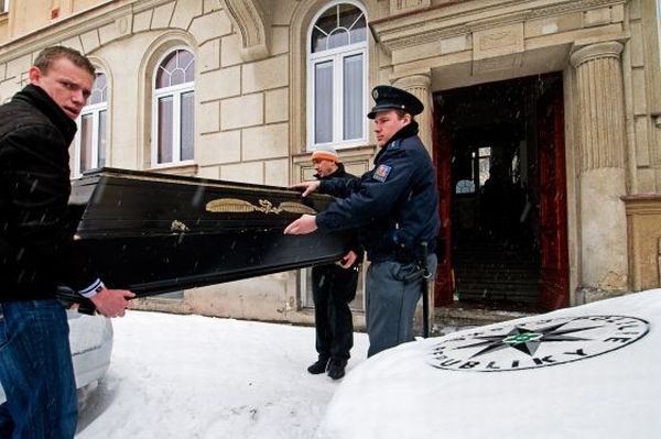 Zaměstnanci pohřební služby vynášejí rakev po dvojnásobné vraždě.