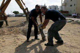 Izraelská bezpečnost u trosek palestinské rakety dopadlé na Sderot.