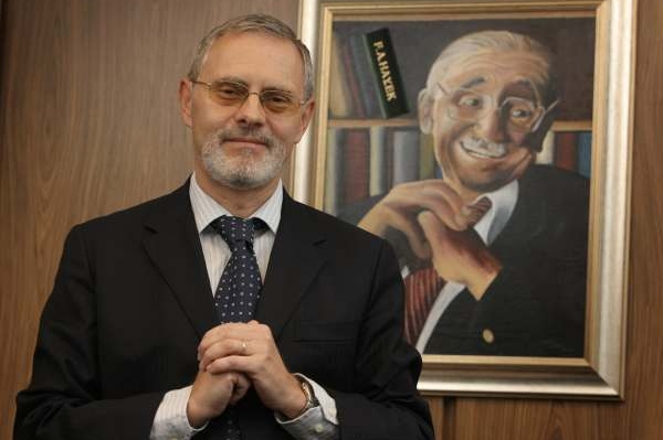 Robert Holman před portrétem ekonoma Friedricha Augusta von Hayeka.