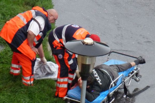 Zdravotníci ošetřují zraněného policistu.
