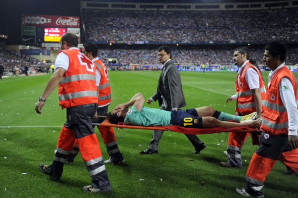 Zraněný Lionel Messi je odnášen na nosítkách po zákroku Tomáše Ujfalušiho.