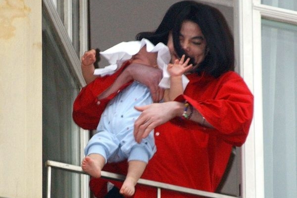 Zpěvák Michael Jackson se synem, který mu málem vypadl z náruče.