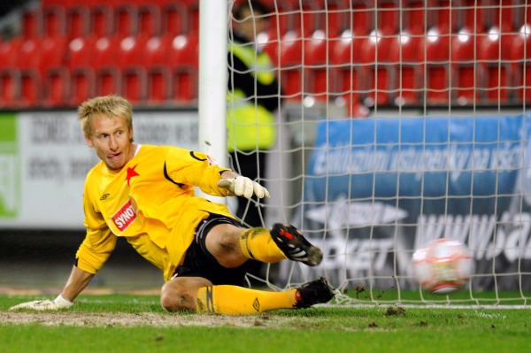 Brankář Slavie Zdeněk Zlámal dostává gól z penalty.