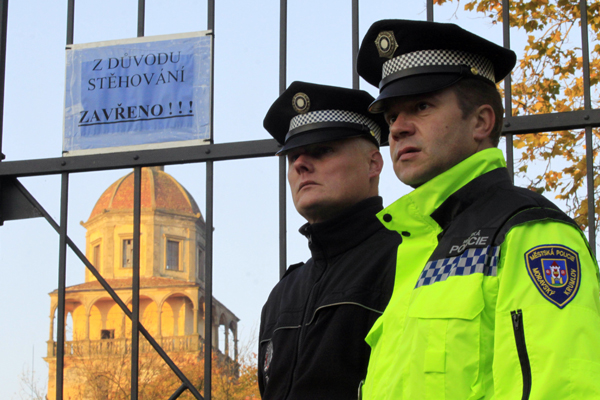 Zavřenou bránu moravskokrumlovského zámku hlídají policisté.