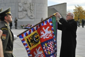 Klaus zavěšuje na vlajku se státním znakem šerpu.