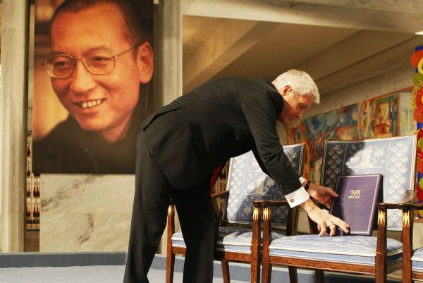 Thorbjörn Jagland, předseda Norského Nobelova výboru, předává symbolicky cenu.