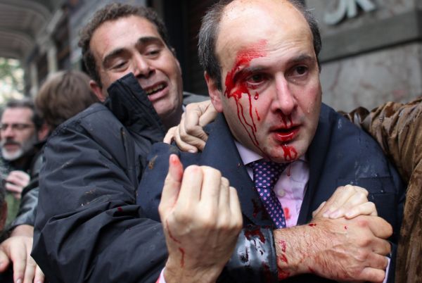 Demonstranti zaútočili na exministra dopravy Kostase Hadzidakise, když vycházel z kavárny.