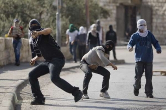 Palestinská omladina hází kameny při protestu proti židovským sídlištím na východě Jeruzaléma.