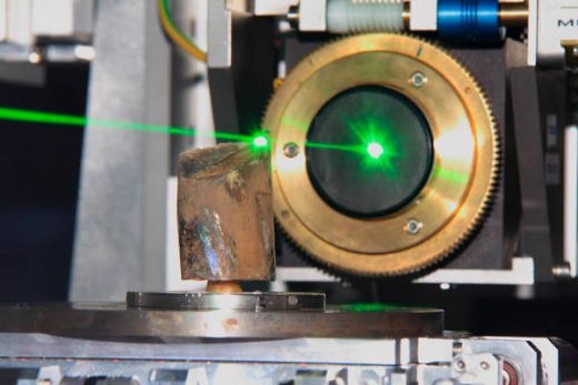 Výzkum fosilie pomocí rentgenového záření produkovaného elektrony urychlenými v synchrotronu. (Neviditelné rentgenové záření zvýrazněno laserovým paprskem.) Výzkum fosilie pomocí rentgenového záření produkovaného elektrony urychlenými v synchrotronu. (Neviditelné rentgenové záření zvýrazněno laserovým paprskem.)