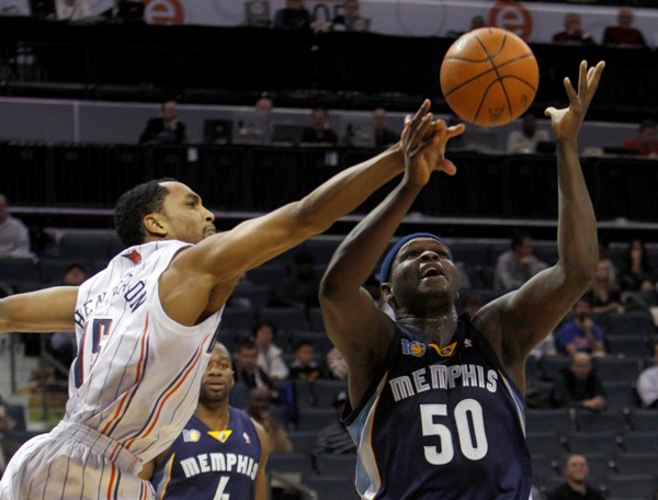 Hráči Bobcats a Grizzlies bojují o míč, za nimi poloprázdné tribuny.