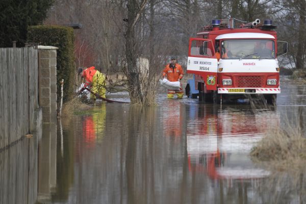 Hasiči připravují hráze z pytlů s pískem v Bdeněvsi na Plzeňsku, kde 15. ledna stoupala hladina Mže kvůli přeplněné přehradě Hracholusky ležící několik kilometrů nad obcí. 