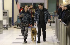 Policisté se psem prošetřují místo atentátu.