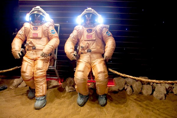 Dvojice astronautů vystoupí ve skafandrech na napodobeninu marsovského povrchu.