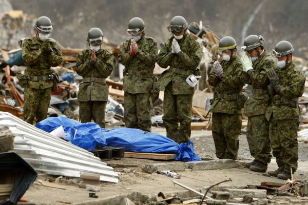 Příslušníci japonské armády nad těly obětí ničivého tsunami. Příslušníci japonské armády nad těly obětí ničivého tsunami.