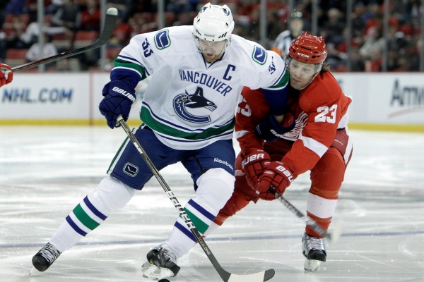 Henrik Sedin z Vancouveru v souboji s Bradem Stuartem.
