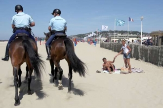 Policisté koňmo na pláži v Deauville.