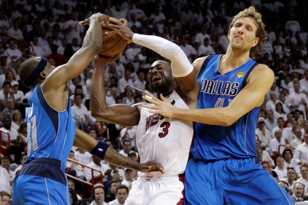 Dirk Nowitzky (vpravo) a Jason Terry z Dallasu brání Dwyanea Wadea z Miami.