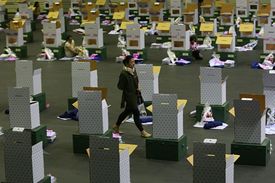 Volební úřednice kráčí mezi urnami na lístky připravenými k rozvozu na volební místa v Bangkoku.