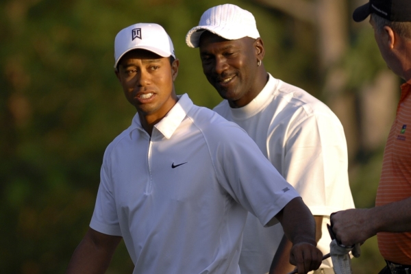 Tiger Woods (vlevo) debatuje s Michaelem Jordanem (archivní foto).