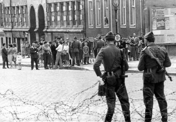 V Bernauer Strasse vyrostl, stejně jako jinde, nejdříve plot z ostnatého drátu.