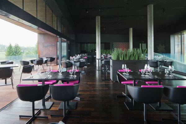 Interiéru vévodí tmavé barvy, zvenčí do restaurace proniká dostatek světla.