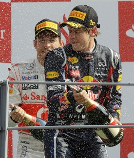 Sebastian Vettel na stupních vítězů, v pozadí druhý muž VC Itálie Jenson Button.