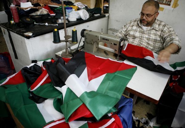 Palestinský krejčí šije vlajky "budoucího" státu. Palestinský krejčí šije vlajky "budoucího" státu.
