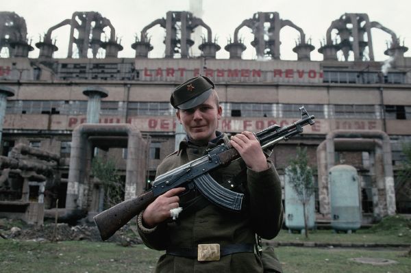 Památky na Hodžovy časy. Voják před továrnou v Albánii v polovině 90. let 20. století.