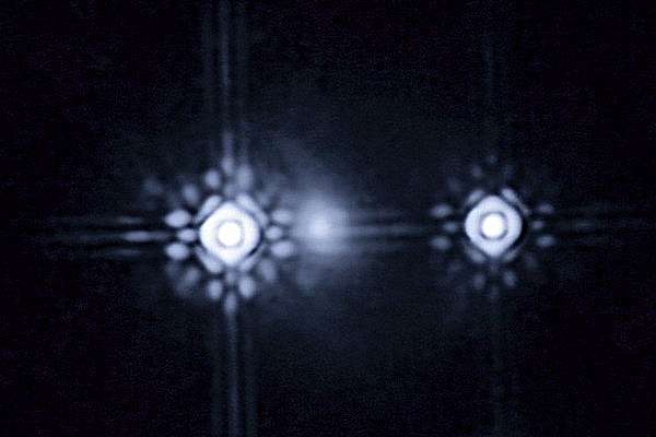 Kvazar (vlevo i vpravo) pozorovaný díky gravitační čočce tvořené vzdálenou galaxií.
