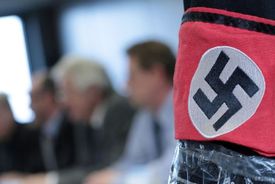 Policie představuje na tiskovce svastiku, která možná patřila útočníkovi, a jednoho tureckého obchodníka.