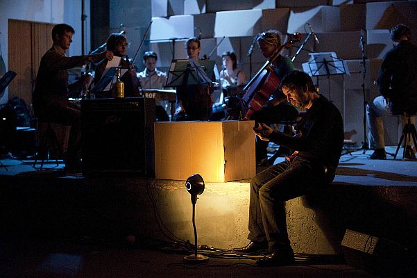 Orchestr Berg při náročném představení, kdy se muzikanti pohybují po celém sále.