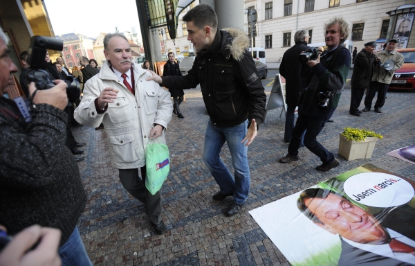 Účastník protestní akce (vpravo) odhání bývalého předsedu ČSNS 2005 Karla Janka od plakátu Jiřího Paroubka před Obecním domem v Praze.