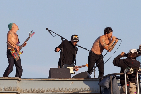 Red Hot Chili Peppers při letním koncertě na střeše. 