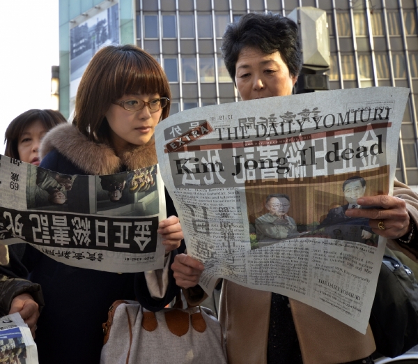 Japonky čtou v Tokiu speciální vydání novin ke Kim Čong-ilově smrti.
