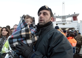 Policista drží malé dítě evakuované z lodi.