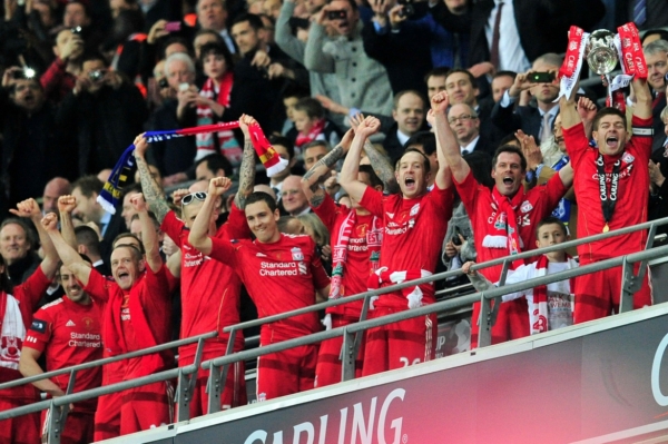 Fotbalisté Liverpoolu se radují s trofejí pro vítěze anglického Ligového poháru.