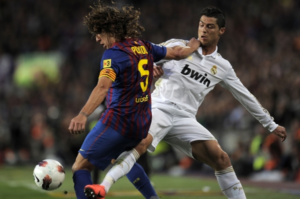 Barcelonský obránce Puyol v souboji s Cristianem Ronaldem.