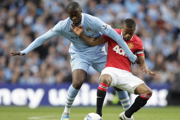 Yaya Toure z Manchesteru City (vlevo) v souboji s kapitánem United Patricem Evrou.