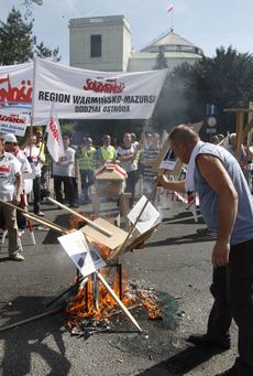 Polští odboráří minulý pátek při protestech pálili fotografie s poslanci, kteří podpořili penzijní reformu.