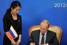 Putin podepisuje dokumenty po jednání v Pekingu.