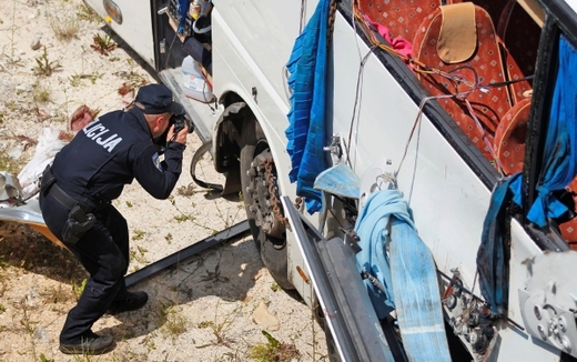 Policista zkoumá vrak autobusu. Policista zkoumá vrak autobusu.