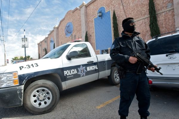 Policista v Ciudad Juarez chrání své kolegy ubytované v hotelu. 