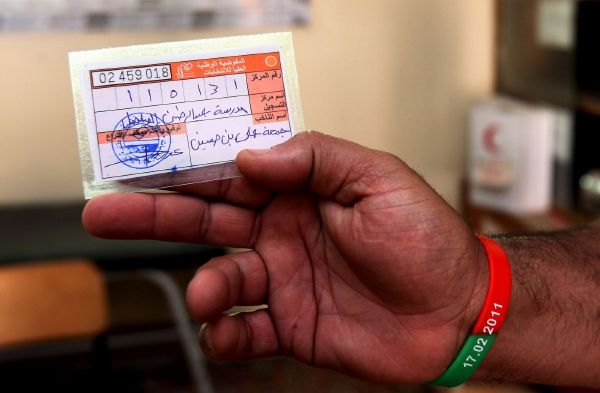 Libyjec ukazuje svou volební registraci. Libyjec ukazuje svou volební registraci.