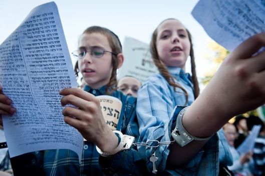Mladí utraortodoxní studenti na demonstraci proti jejich rekrutování do armády. 