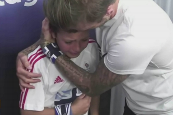 David Beckham utěšuje malého chlapečka, který právě spatřil svůj idol.