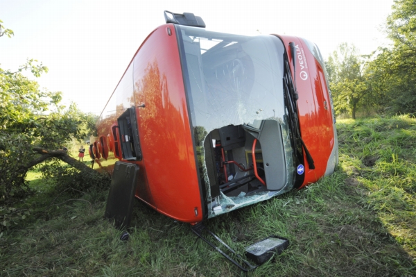Autobus vyjel ze silnice a převrátil se na bok.