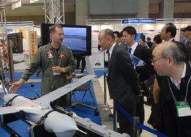 Americký pilot vysvětluje na veletrhu v Tokiu, jak funguje Scan Eagle Unmanned Aerial Vehicle (UAV).